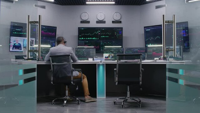 Multi ethnic team of traders work on multi-monitor computers with displayed real-time stocks. Colleagues analyze exchange market charts on big screens. Cryptocurrency trading and analytics. Timelapse.