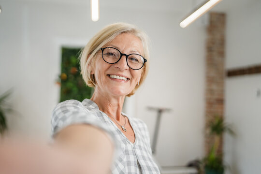 Portrait of one mature blonde caucasian woman with eyeglasses at home