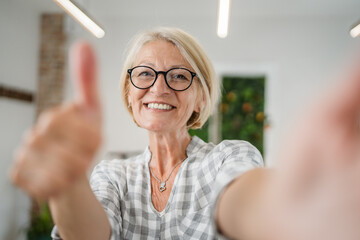 Portrait of one mature blonde caucasian woman with eyeglasses at home