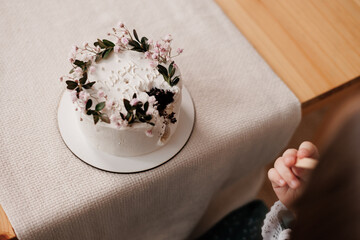 Cropped shot of unrecognisable little girl is eating with wooden spoon decorated flowers birthday...