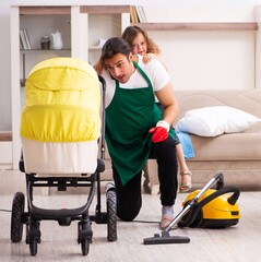 Young male contractor cleaning the house with his small daughter