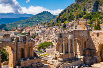 Taormina on Sicily, Italy. Ruins of ancient Greek theater, mount Etna covered with clouds. Taormina...