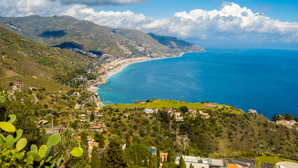 Fototapeta na wymiar Landscape of Sicialian coast near Taormina town, Sicily, Italy. Mountains and azure waters of Ionian sea. Popular resort and tourist destination in southern Italy