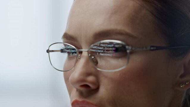 Developer glasses reflecting code lines closeup. Woman hacker programming app