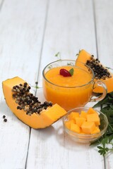 Papaya juice, slices on the table, chopped papaya salad, smoothie, in a transparent mug, vitamin drink, exotic fruit, background image, background, photo background