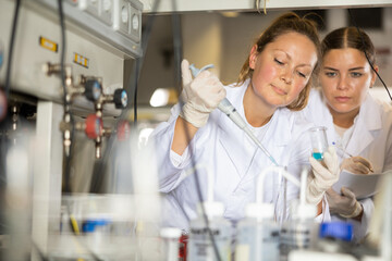 Woman scientist and her assistant conduct scientific experiments in a chemical laboratory