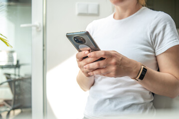 The woman uses a mobile phone. Casual style.