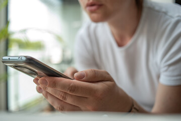 The woman uses a mobile phone. Casual style.