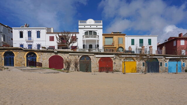Colorful doors of storages on sandy beach and houses in the touristic town of Calella de Palafrugell, Mediterranean, Spain, Costa Brava, Catalonia, Baix Emporda