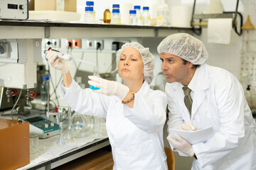 Scientist and his assistant conduct scientific experiments in a chemical laboratory