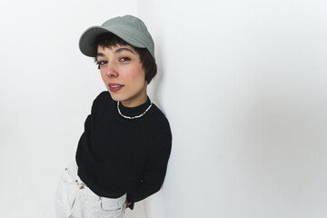 High angle shot of a female modedl wearing a cap and smiling mysteriously at the camera. High quality photo