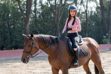 Fototapeta premium Portrait of a young woman riding a horse making a funny face