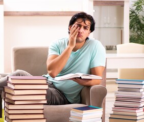 Male student with many books at home