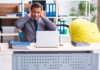 Young male employee looking after newborn at workplace