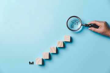 Hand holding a magnifying glass with education icons on a blue background. education concept....
