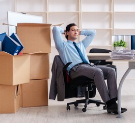 Young man employee with boxes in the office