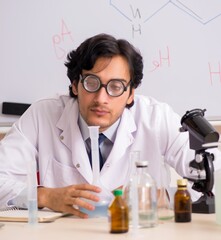 Young funny chemist in front of white board