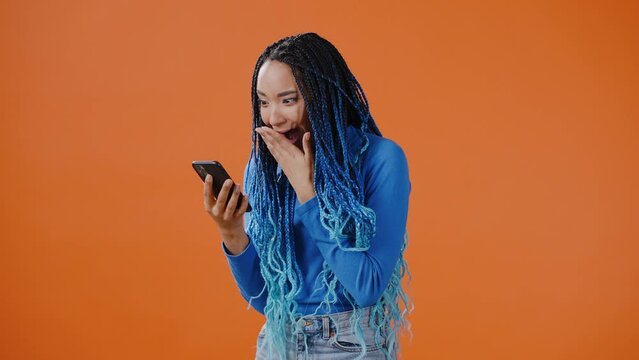 Young lady looks at phone and points finger recommending app