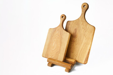 Two homemade wooden cutting boards made of solid oak with round handles and a stand on a white background. Daylight. Photo. Copy space.