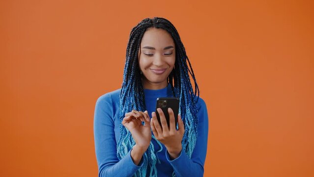 Smiling African American woman chooses goods using phone