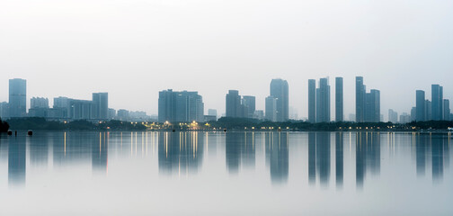 Obraz premium Reflection of modern city buildings in water at morning