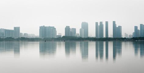Reflection of modern city buildings in water at morning