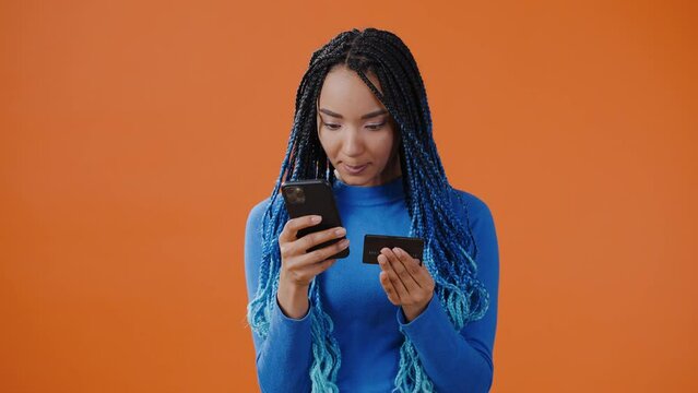 Concentrated woman enters credit card information into phone