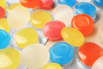 Blisters and many colorful cough drops as background, closeup