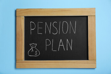 Chalkboard with phrase Pension Plan on light blue background, top view