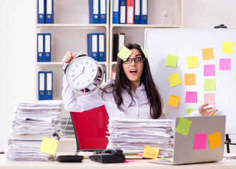 Young female employee in conflicting priorities concept