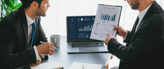 Busy analyst team discussing financial data on digital dashboard, analyzing chart and graph using...