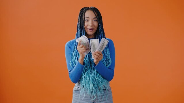 Woman counts money and throws dollar bills upward dancing