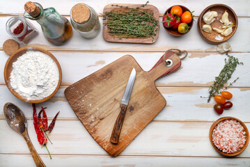 cutting board, ingredients and spices on a white kitchen table. View from above. Space for text and menu.