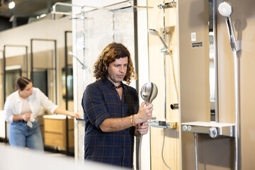 Man looking to buy new shower fixture for bathroom in store