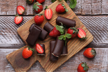Delicious glazed curd snacks with fresh strawberries and mint on wooden table, flat lay