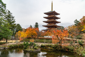 Fototapeta premium Pagode du temple Nariaiji à Amanohashidate, Japon. Plan d'eau et érables rouges en automne.