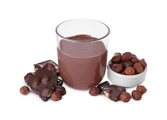 Chocolate pieces, glass of delicious paste and hazelnuts on white background