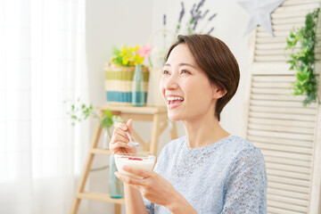 自宅でヨーグルトを食べる女性