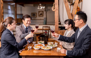 居酒屋で忘年会・新年会・飲み会・宴会をする仕事仲間・同僚・上司部下の男女
