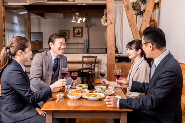 居酒屋で忘年会・新年会・飲み会・宴会をする仕事仲間・同僚・上司部下の男女

