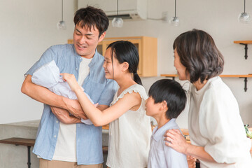 赤ちゃんを抱っこするパパと家族・ファミリー
