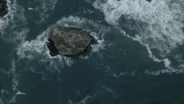 Raining fog Canon Beach Oregon drone aerial cinematic looking down haystacks rock coastline wave cloudy afternoon gray Pacific Ocean Arcadia highway 101 Oswald west stunning ocean slowly circling