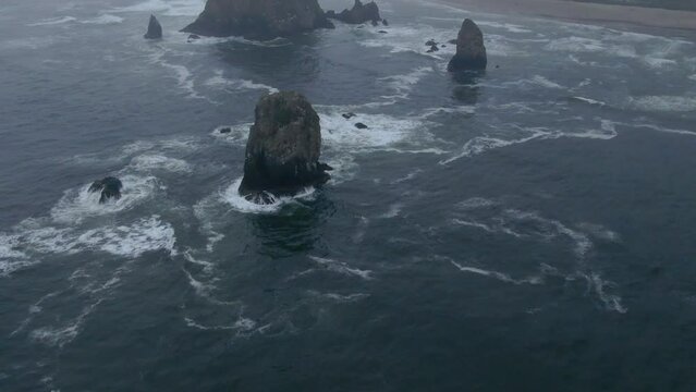 Raining fog Canon Beach Oregon drone aerial cinematic haystacks rock coastline wave cloudy afternoon gray Pacific Ocean Arcadia highway 101 Oswald west stunning ocean coastline America pan up forward