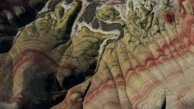 Painted Hills Oregon Aerial drone cinematic stunning mountainside desert unreal Mars colorful earth vivid  red orange yellow near Bend around noon mid day John Day Fossil Carroll Rim circling left