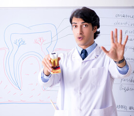 Young handsome dentist in front of the whiteboard