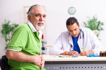 Old man visiting young male doctor gastroenterologist