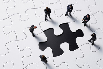 パズルのピースを見つめるビジネスマン