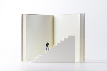 本を読む階段の上のビジネスマン