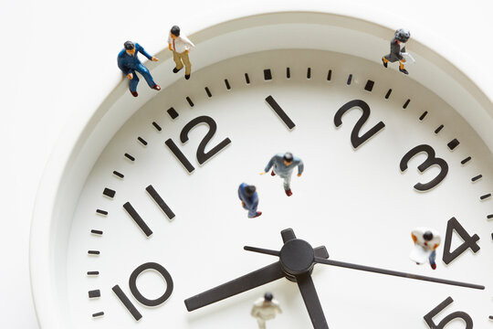 時計の上のミニチュアサラリーマン
