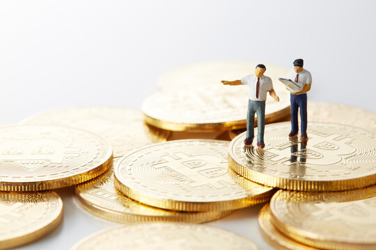 ビットコインの上のミニチュアのサラリーマン